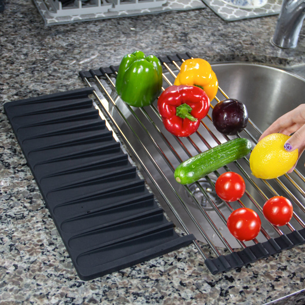 A foodie is using the Over Sink Roll-Up Dish Drying Rack with Silicone Drip Tray from Grand Fusion Housewares, LLC to prep vegetables in a kitchen sink.