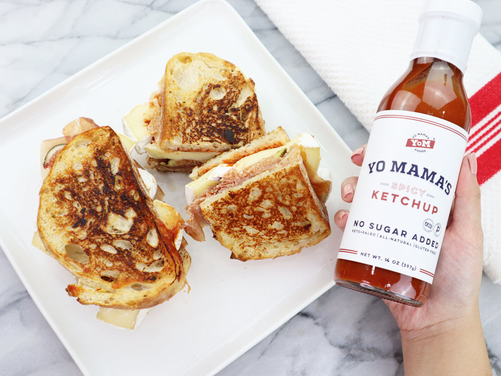 Foodies can enjoy grilled sandwiches with a bottle of Spicy Ketchup by Yo Mama's Foods, served on a plate from the XSpecial Marketplace.