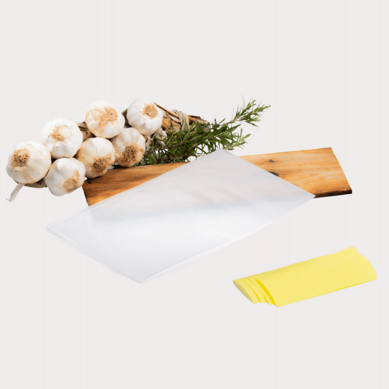 A Meat Lovers' DryAgingBags™ cutting board adorned with garlic and herbs, perfect for Foodies.