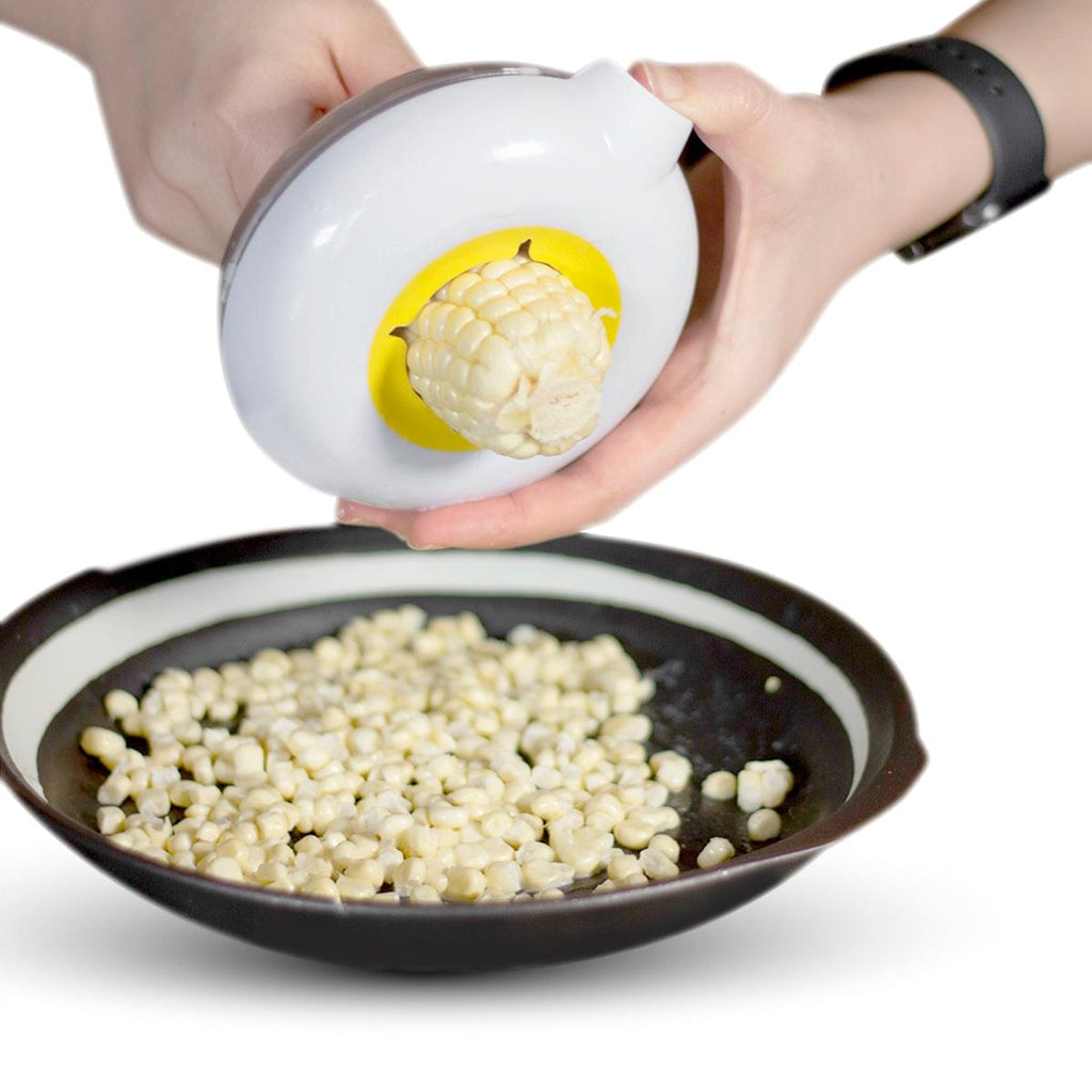 A person is holding a Grand Fusion Housewares, LLC Corn Peeler with Circular Stainless Steel Blade that strips the corn cob cleanly - the plastic container with pouring spout catches kernels.
