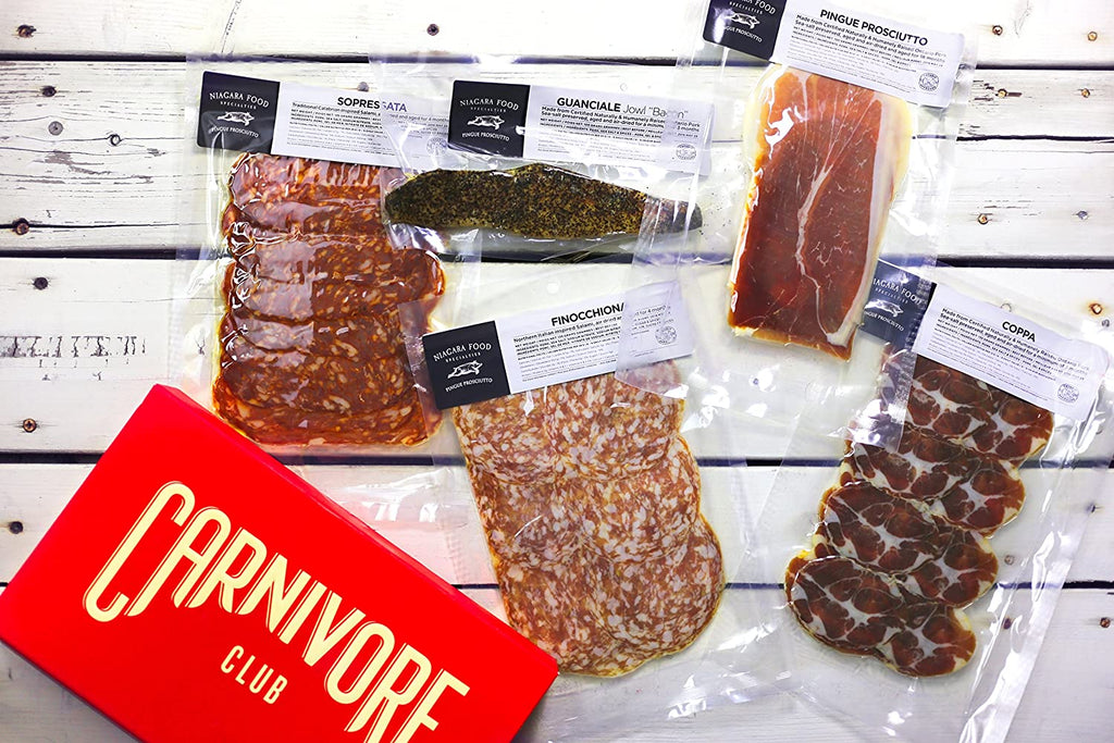 A classic meat sampler by Carnivore Club USA, presented in a plastic bag on a wooden table.
