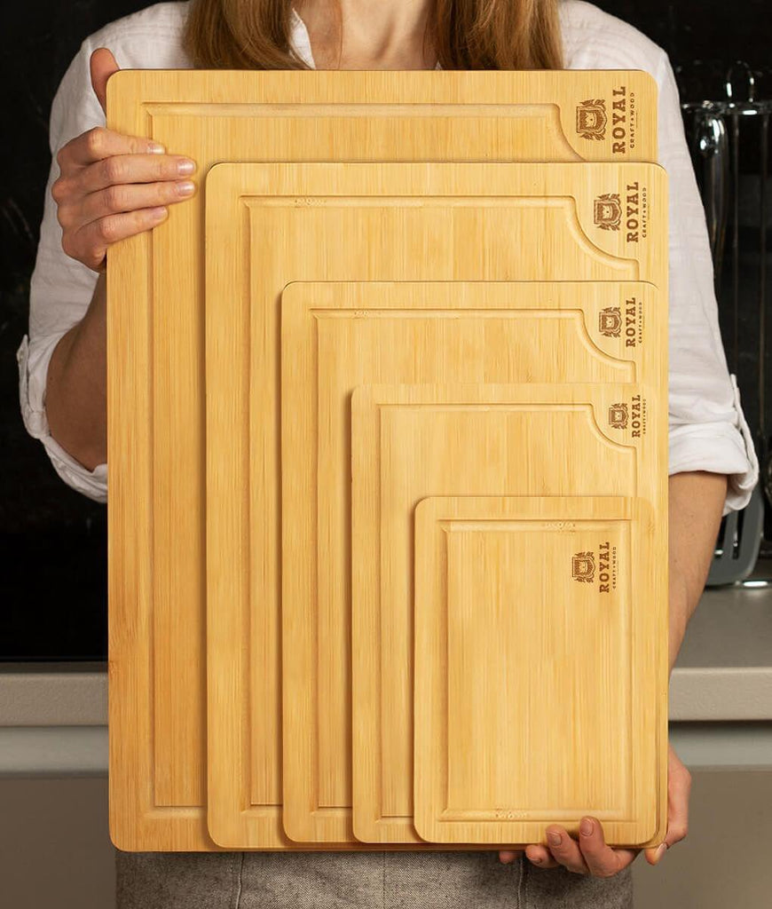A woman showcasing the Royal Craft Wood Bamboo Chopping Board Set of 5 Piece and the XSpecial Marketplace Meat Tenderizer Tool.