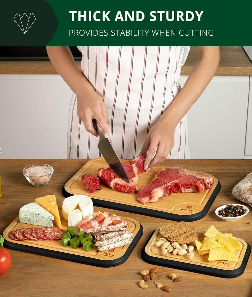 A woman using a Blade Meat Tenderizer Tool to cut meat on a Black Wood Cutting Board Set Of 3 by Royal Craft Wood.