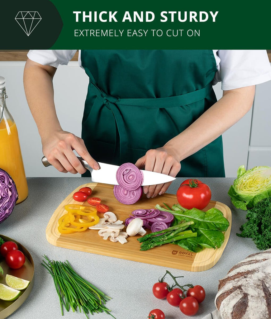 A foodie woman using the Blade Meat Tenderizer Tool on a Luxury Cutting Board 2 Tone by Royal Craft Wood while cutting vegetables.