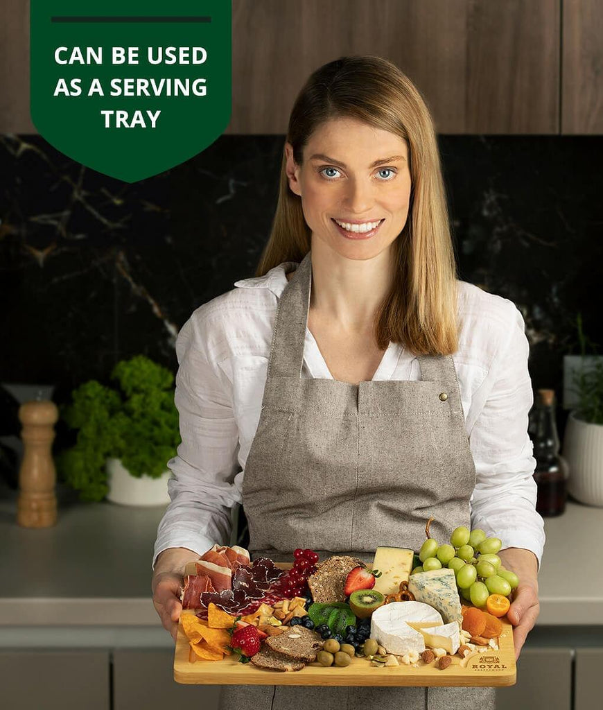 A woman holding a tray of food, serving as an XSpecial fruit cutting board by Royal Craft Wood.