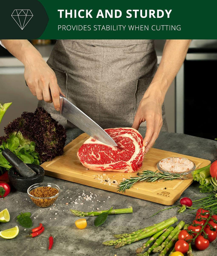 A foodie slicing a steak on a Royal Craft Wood Fruit Cutting Board 15x10", using a blade meat tenderizer tool.