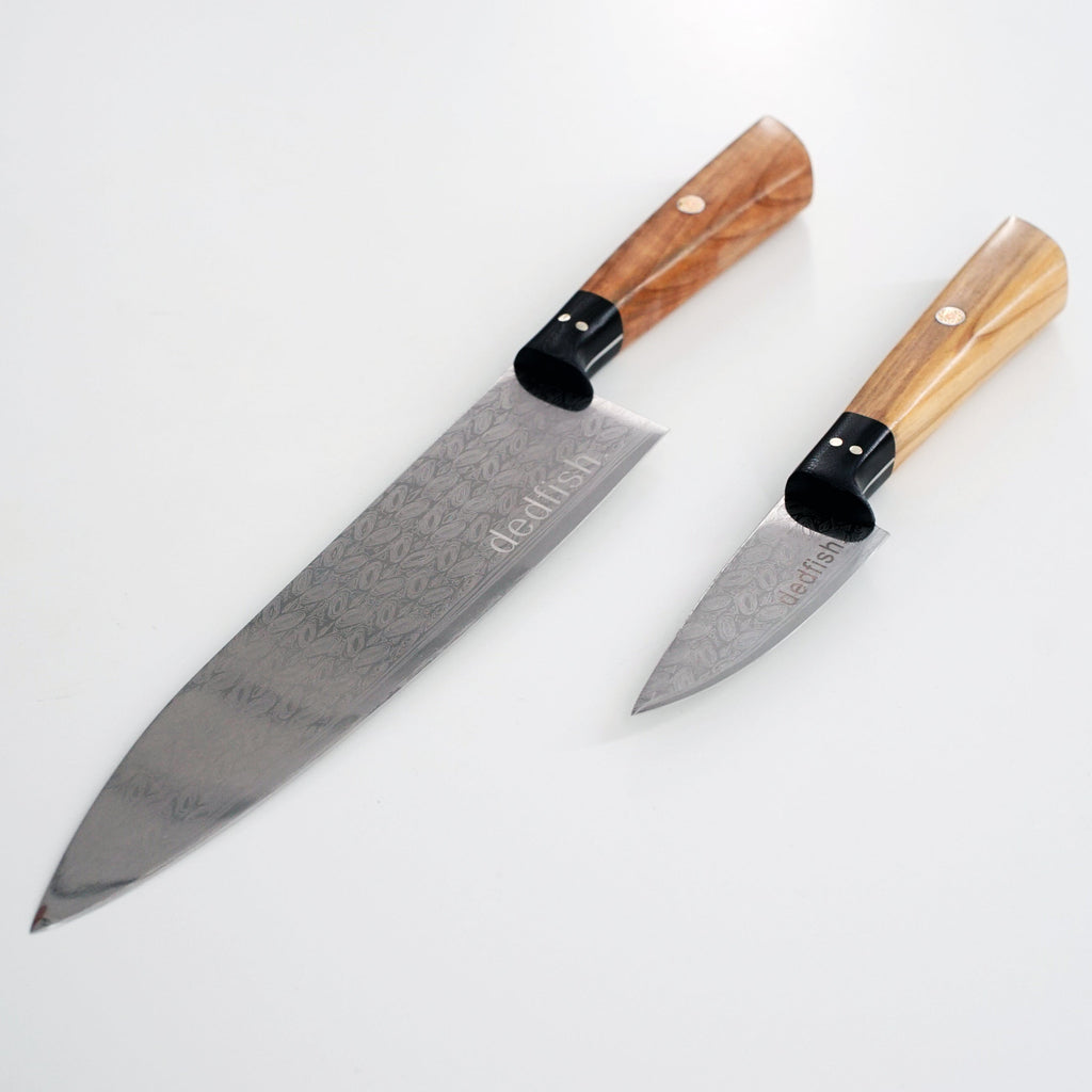 Two XSpecial Dedfish Co. Kitchen Knives with wooden handles perfect for meat lovers, placed on a white surface.