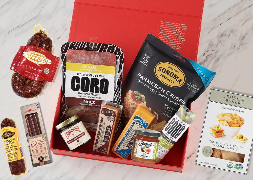 A red box filled with Classic Box Meats & Jams, Crackers, Cheese for Meat Lovers and Foodies by Carnivore Club USA.