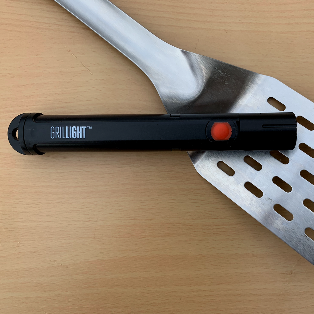 A Grillight.com Spatula Flashlight for Foodies on a wooden table.