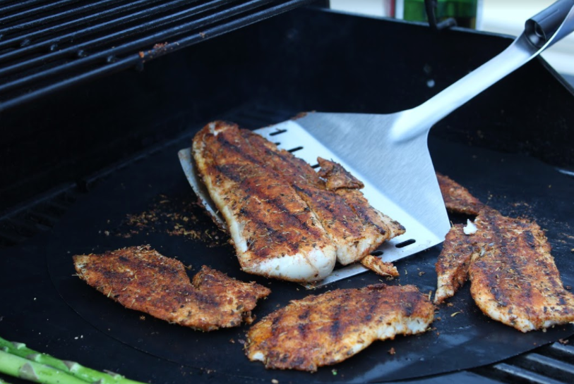 Grilled fish on a grill with a Grillight.com LED Spatula - Giant Edition for foodies.