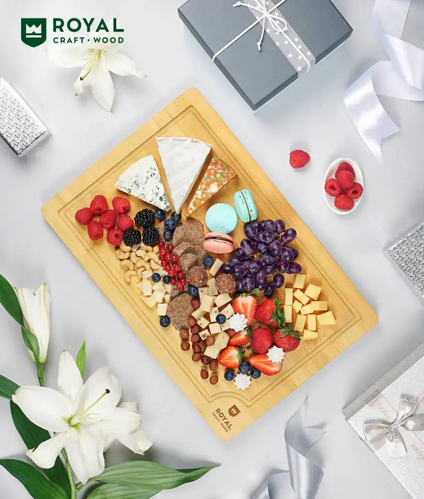 A Royal Craft Wood Bamboo cutting board 12x18 with foodies and cheese on it.