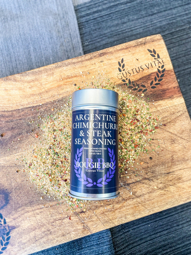 A tin of Gustus Vitae Argentine Chimichurri & Steak Seasoning sitting on a cutting board.