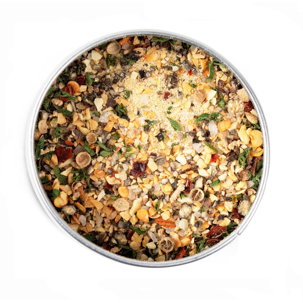 A bowl full of mixed vegetables and nuts with Chop House Choice BBQ Seasoning by Gustus Vitae on a white background.