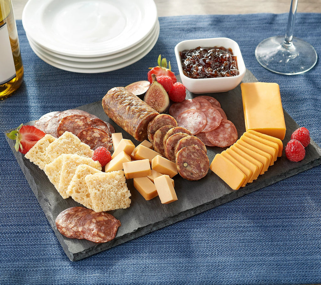 A Carnivore Club USA slate board with a variety of Classic Box Meats & Jams, Crackers, and Cheese for Meat Lovers from the XSpecial Marketplace.