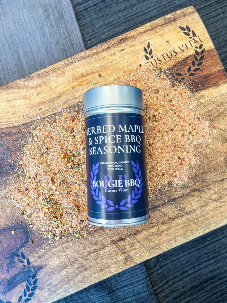 An artisanal can of Herbed Maple & Spice BBQ seasoning by Gustus Vitae on a wooden cutting board.