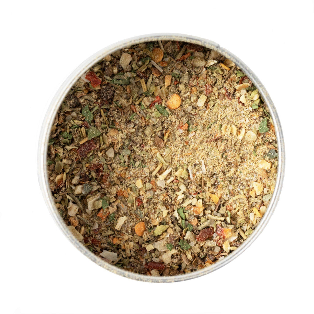 A bowl of artisanal dried herbs and spices on a white background, perfect for seasoning New Zealand Lamb & Game BBQ Rub by Gustus Vitae with natural ingredients.