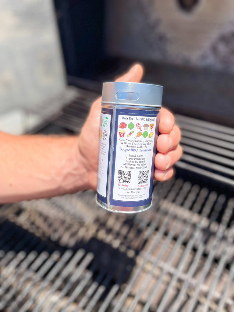 A person grilling with Gustus Vitae's Salt & Sugar Free Steak Seasoning, an all natural blend of artisan seasoning.