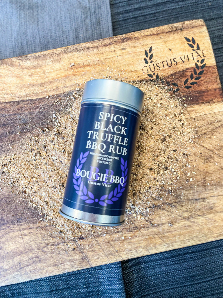 A gourmet tin of all-natural Gustus Vitae Spicy Black Truffle BBQ rub on a cutting board.