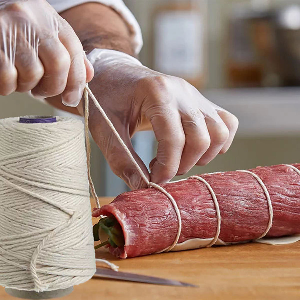 A person cutting a piece of meat with a Regency Wraps Cotton Butchers Cooking Twine For Meat Trussing from Grand Fusion Housewares, LLC, using the XSpecial blade meat tenderizer