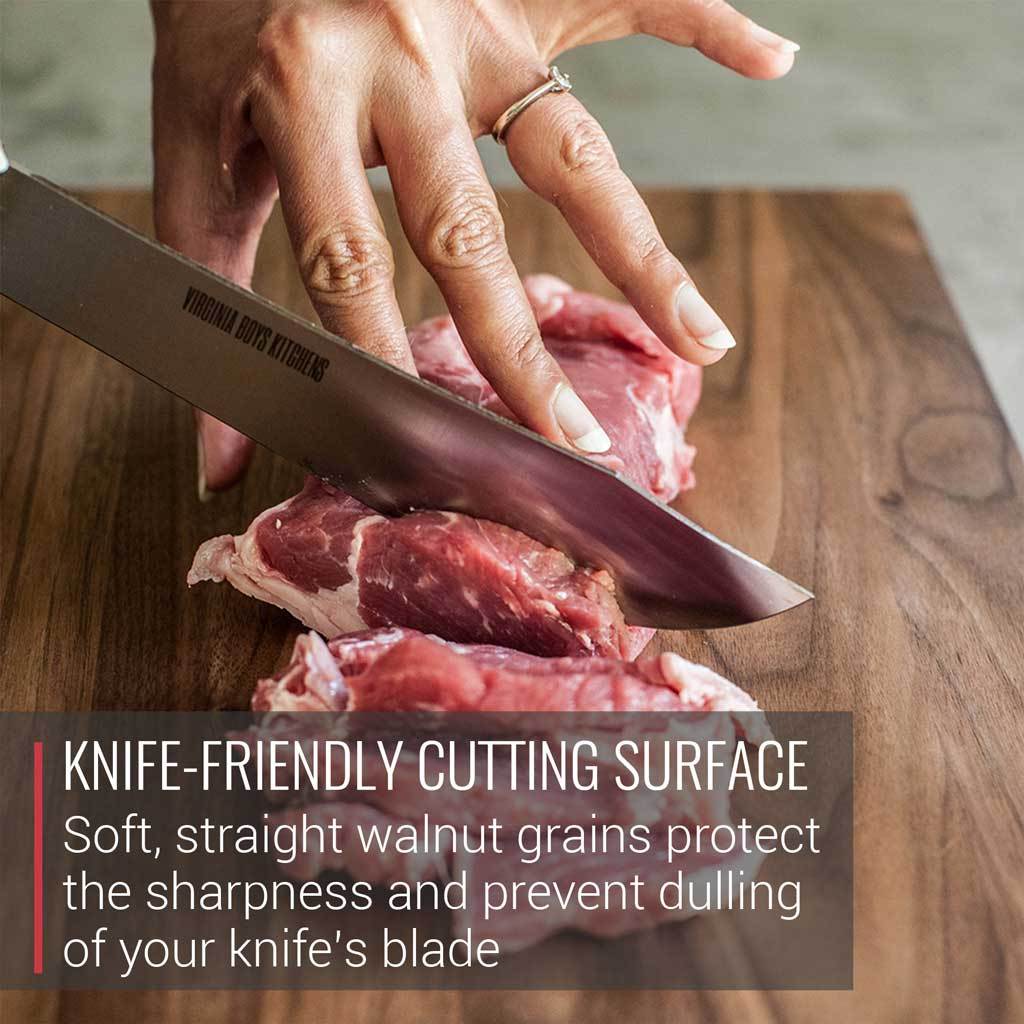 A person using a Blade Meat Tenderizer Tool on a Virginia Boys Kitchens Medium Walnut Wood Cutting Board.