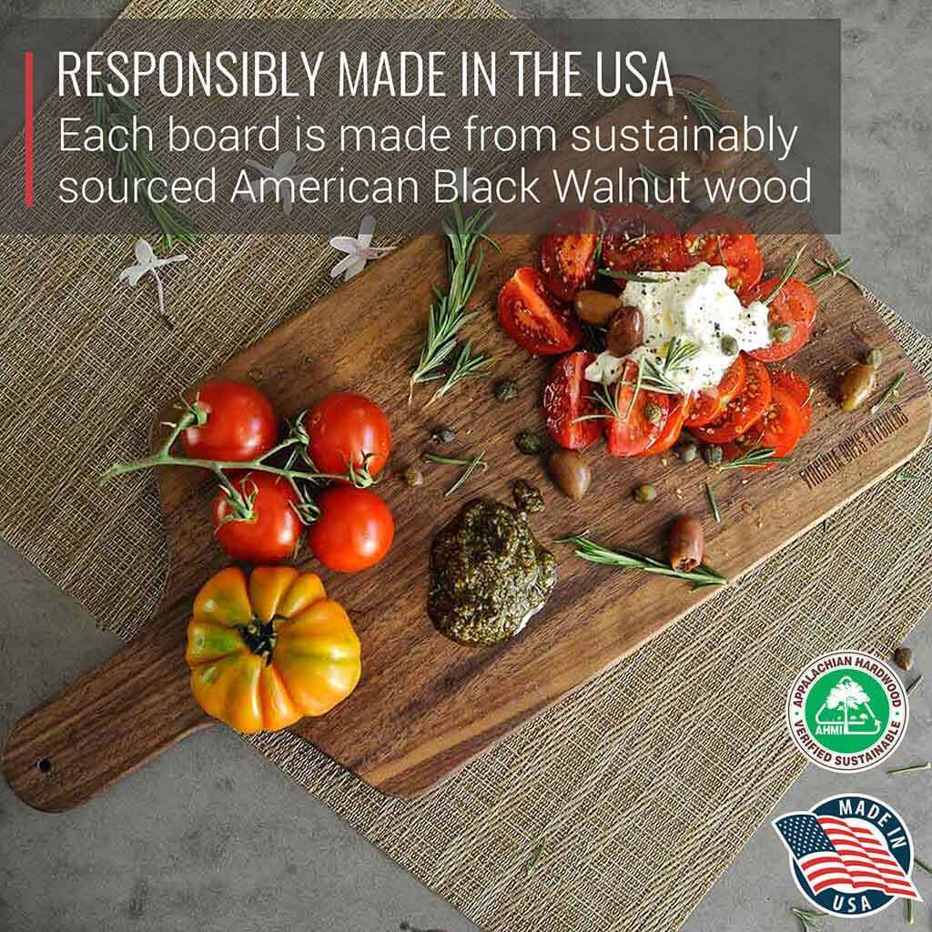 Each sustainably sourced black wood Walnut Cutting Board and Charcuterie Paddle from Virginia Boys Kitchens includes a handle for easy handling.