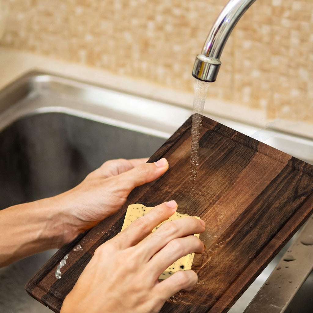 A Foodie washing a Virginia Boys Kitchens Clean & Care Kit for Wood Cutting Boards in a sink.