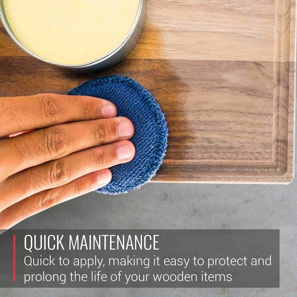A person cleaning a wooden cutting board with a cloth using the Complete Care Kit for Wood Cutting Boards by Virginia Boys Kitchens from XSpecial Marketplace.